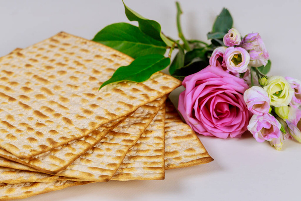 Matzah bread with pink roses. Jewish Passover holiday concept. - Photo, Image