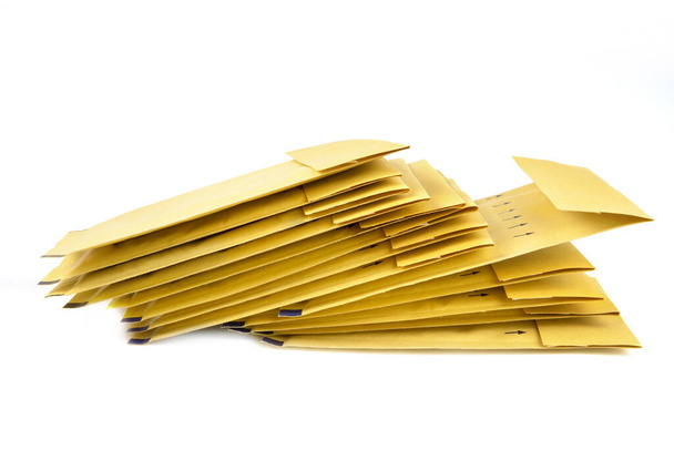 A pile of yellow packing envelopes isolated on white. - Photo, image