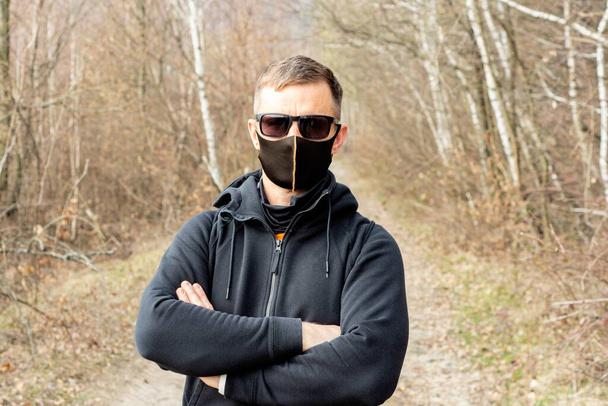 Healthcare and medicine concept. Portrait of man wearing protective mask outdoors to prevent coronavirus, covid-19, germs, toxic fumes and dust - Photo, Image