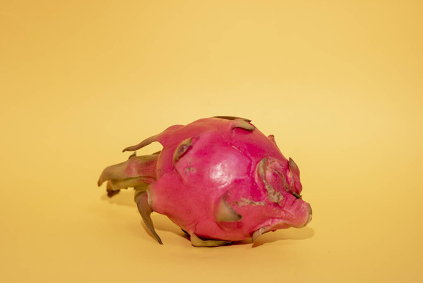 Szaftos rózsaszín pitaya sárga papíron, felülnézetből és másolás helyet. Vízszintes - Fotó, kép