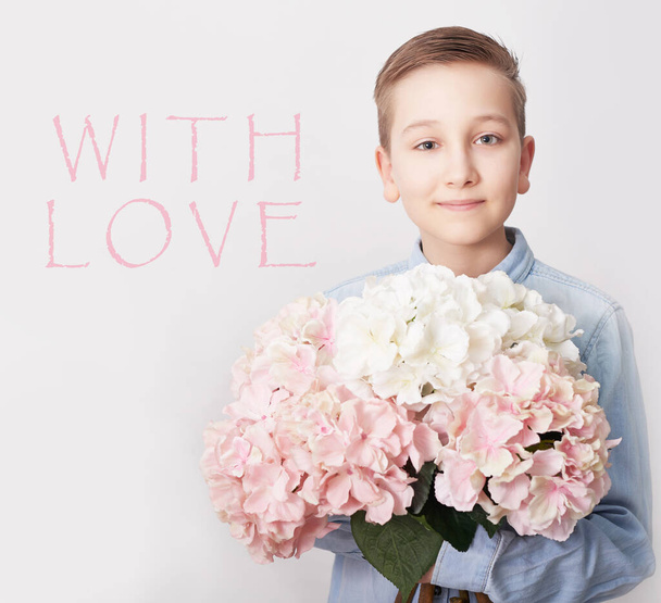 Child boy with bouquet of flowers. Mother's Day Greeting Card. Happy mothers day frame background. Spring card template. Happy Birthday or Valentine. Women's Day. Copy space. Child gives bouquet. - Фото, изображение