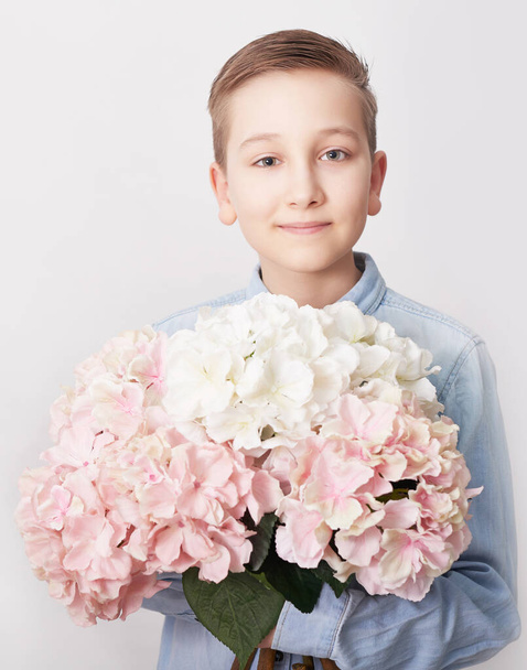 Child boy with bouquet of flowers. Mother's Day Greeting Card. Happy mothers day frame background. Spring card template. Happy Birthday or Valentine. Women's Day. Copy space. Child gives bouquet. - Fotó, kép
