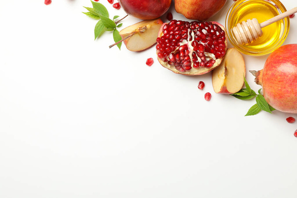 Omena, hunaja ja granaattiomena valkoisella taustalla, tilaa tekstille
 - Valokuva, kuva