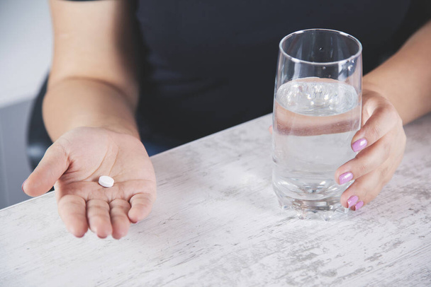 woman hand drug with water on desk - Valokuva, kuva