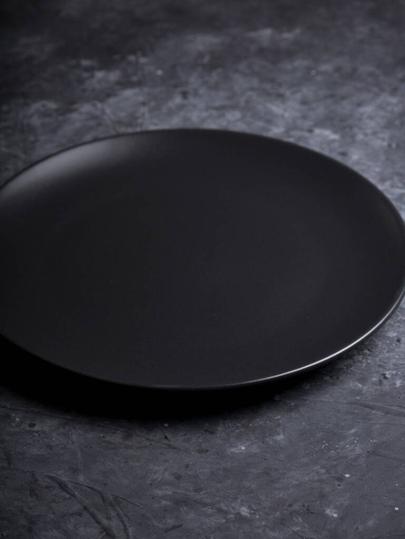 černý talíř na černém pozadí. minimalizuje jídlo zůstat. foto jídla - Fotografie, Obrázek