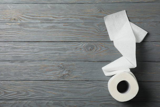 Rolka papieru toaletowego na drewnianym tle, miejsce na tekst - Zdjęcie, obraz