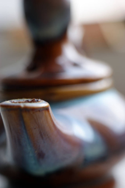 klei bruin-paarse theepot close-up met deksel en schenkkan - Foto, afbeelding