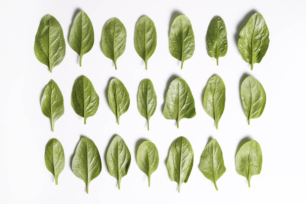 Clean eating concept. Leaves ripe juicy freshly picked organic baby spinach greens laid in pattern, isolated on white background. Healthy diet for spring summer detox. Vegan raw food. Close up. - Φωτογραφία, εικόνα