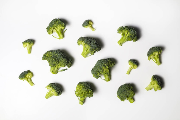 Clean eating concept. Bunch of ripe juicy freshly picked organic broccoli heads, green curds isolated on white background. Healthy diet for spring summer detox. Vegan raw food. Close up. - Foto, Imagem