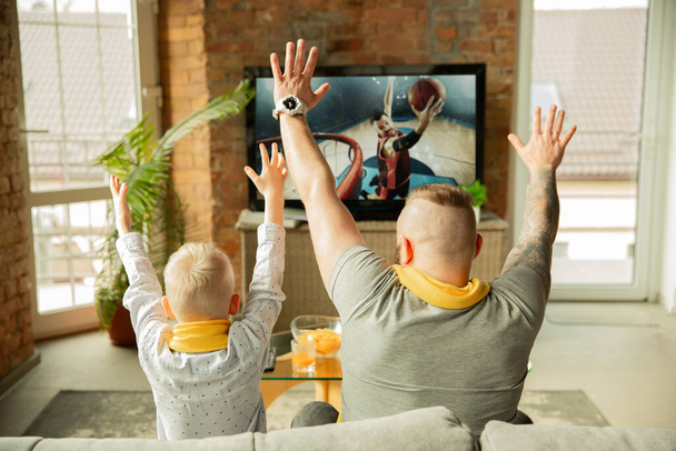 Excited family watching basketball, sport match at home, father and son - Photo, Image