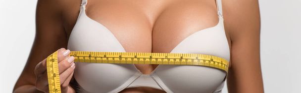 partial view of sexy girl measuring breasts with measuring tape isolated on white, panoramic shot - Photo, Image