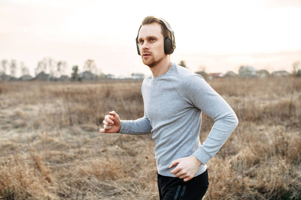 Active lifestyle. Attractive young guy jogging - Photo, Image