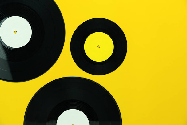 Настольный вид ретро музыкальных инструментов, скрывающий плоские объекты множества музыкальных дисков на современной ржавой желтой бумаге в домашнем офисе.
. - Фото, изображение