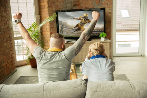 Podekscytowana rodzina ogląda amerykański futbol, mecz sportowy w domu, piękna para - Zdjęcie, obraz