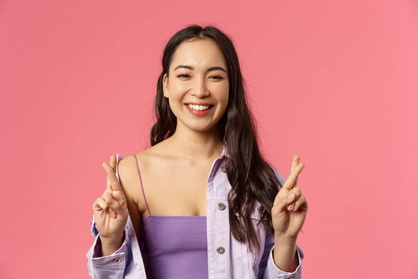 Lähikuva muotokuva optimistinen onnellinen, hymyilevä aasialainen tyttö, jolla usko kaikki on hyvä, rajat sormet onnea, nauraa, toiveikas ennakoida myönteisiä tuloksia, pysyvän vaaleanpunainen tausta
 - Valokuva, kuva