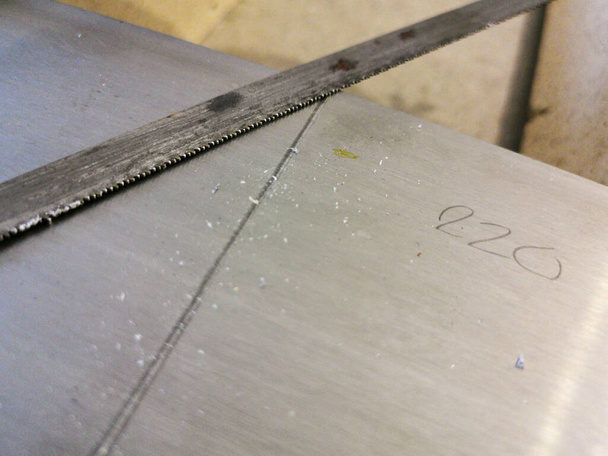 Hoja oxidada de la sierra de mano vieja que corta a través de la placa de aluminio durante el proceso de restauración de muebles en casa
 - Foto, imagen