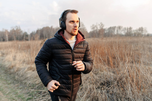 Cardio workout outdoors. Young guy does jogging - Fotografie, Obrázek