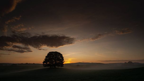 Рассвет над фермерскими угодьями возле деревни Йоркшир Дейлз в Эштоне - маленькой деревне и гражданском приходе в округе Хувен Северного Йоркшира - Фото, изображение