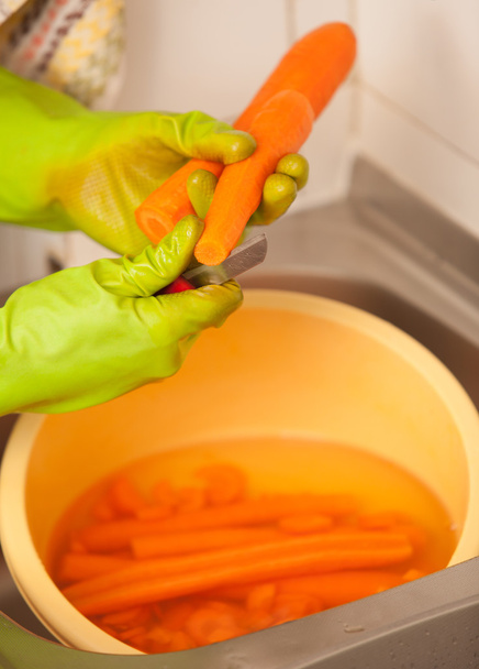 Woman hands slicing carrots in kitchen. Healthy nutrition - Foto, afbeelding