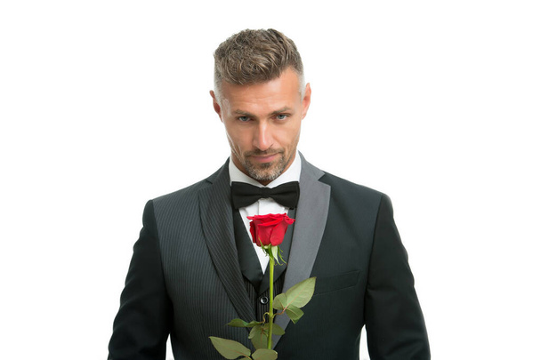 Celebrating womens day. Handsome man hold red rose. Flowers for womens day. Bachelor in formalwear. International womens day. March 8. Floral gift on womens day - Fotó, kép