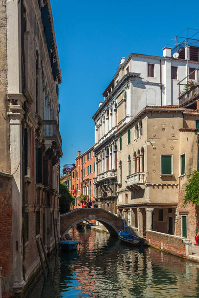 View of narrow Canal with boats and gondolas in Venice, Italy. Venice is a popular tourist destination of Europe - Foto, imagen