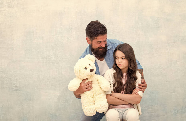 Look at this toy. Father show soft toy to little daughter. Upset child and bearded man with toy bear. Game and play. Toy shop. Stay childish, copy space - Foto, Imagen