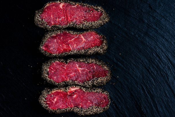 Pepper steaks on stone above view - 写真・画像