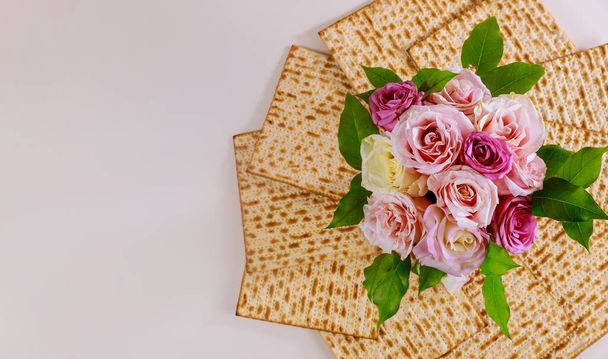 Pane ebreo matzah con rose rosa. Concetto di festa ebraica di Pasqua
. - Foto, immagini