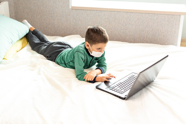 Оставайтесь дома, профилактика пандемии коронавируса. Ребенок учится онлайн на ноутбуке во время карантина. Дистанционное обучение. Эпидемия профилактики. COVID-19
. - Фото, изображение
