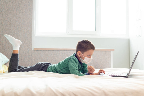 Оставайтесь дома, профилактика пандемии коронавируса. Ребенок учится онлайн на ноутбуке во время карантина. Дистанционное обучение. Эпидемия профилактики. COVID-19
. - Фото, изображение