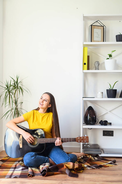 Woman spends leisure playing guitar - Valokuva, kuva