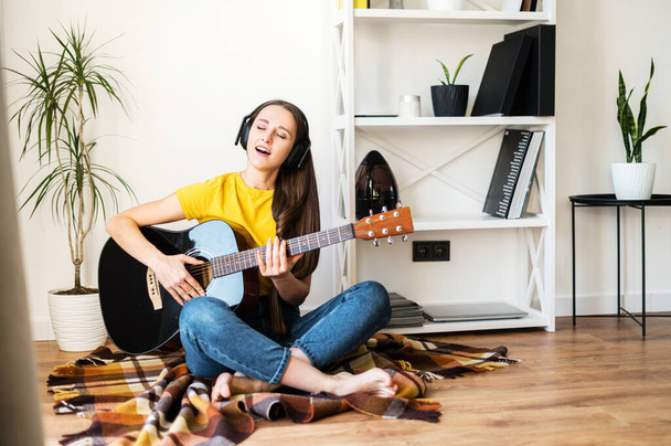 Woman spends leisure playing guitar - 写真・画像