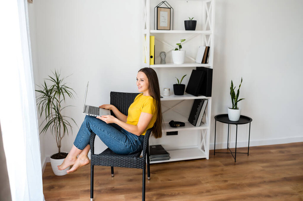 Woman in a cozy home atmosphere with a laptop - Zdjęcie, obraz