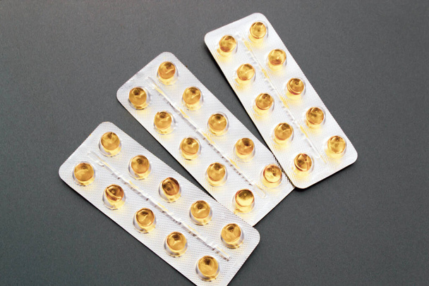 Tabletki, kapsułki, strzykawki z lekami na szarym tle - Zdjęcie, obraz