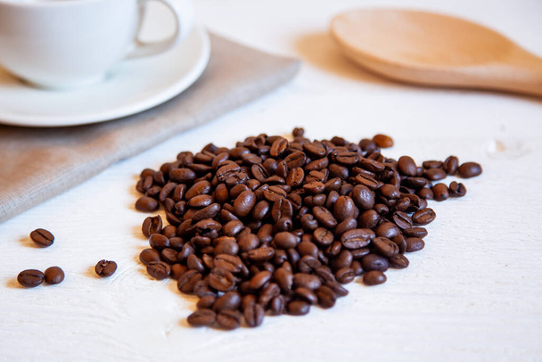 A bunch of coffee beans on the white table. - Фото, зображення