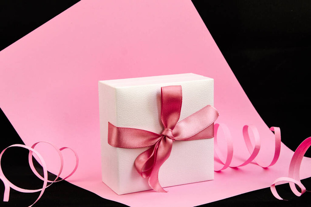 Present box with pink ribbon on the pink and black background, Holiday, Gifts, Copy space, Greeting card - Foto, imagen