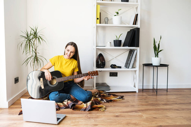 A woman watches video tutorial on guitar playing - Φωτογραφία, εικόνα
