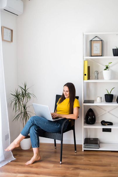 Woman in a cozy home atmosphere with a laptop - Zdjęcie, obraz
