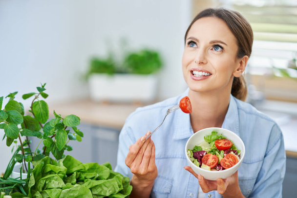 Femme adulte en bonne santé avec des aliments verts dans la cuisine
 - Photo, image