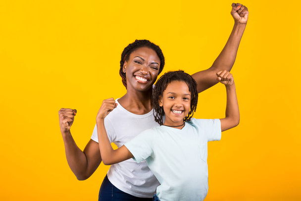 Φάνκυ Αφροαμερικάνα γυναίκα και κορίτσι σηκώνουν τις γροθιές τους. - Φωτογραφία, εικόνα