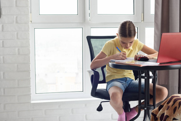 Karanteenissa tyttö tekee läksyjä etäopetuksen kautta
 - Valokuva, kuva