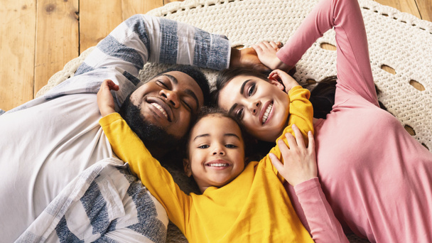 Family evening multiracial family. Daughter hugging parents - Photo, Image