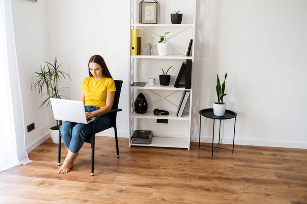 Woman in a cozy home atmosphere with a laptop - Foto, Bild