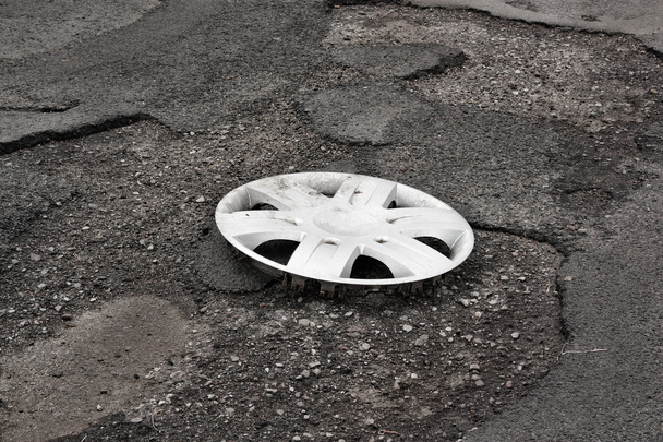 Cubierta de la rueda recortada en la carretera dañada
 - Foto, Imagen