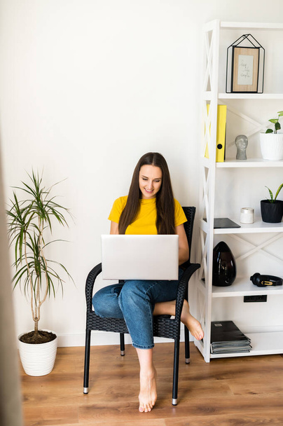 Woman in a cozy home atmosphere with a laptop - Foto, Imagen