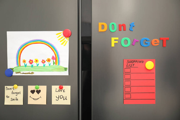 Modern refrigerator with child's drawing, notes and magnets - Foto, afbeelding
