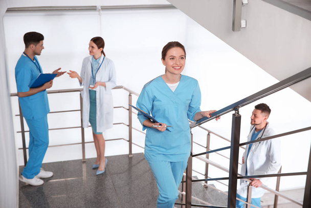 Female doctor going upstairs in modern clinic - Photo, image
