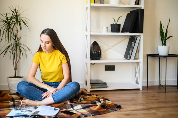 Young attractive girl reads magazines at home - Photo, Image