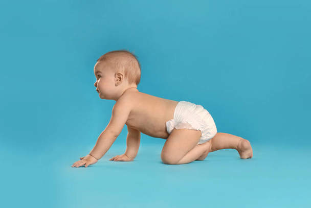 Cute little baby in diaper on light blue background - Photo, Image