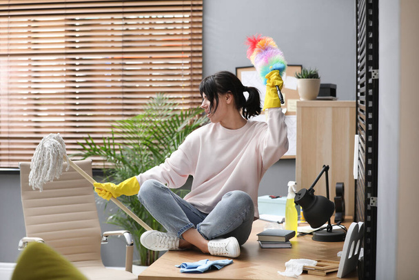 Lazy woman having fun while cleaning at home - 写真・画像